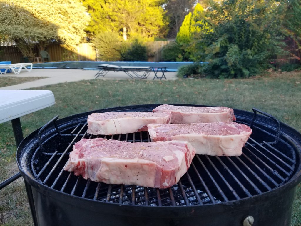 Strip steaks on the smoker with mesquite