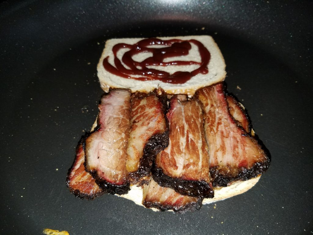 Sliced leftover brisket added on top of the barbecue sauce side