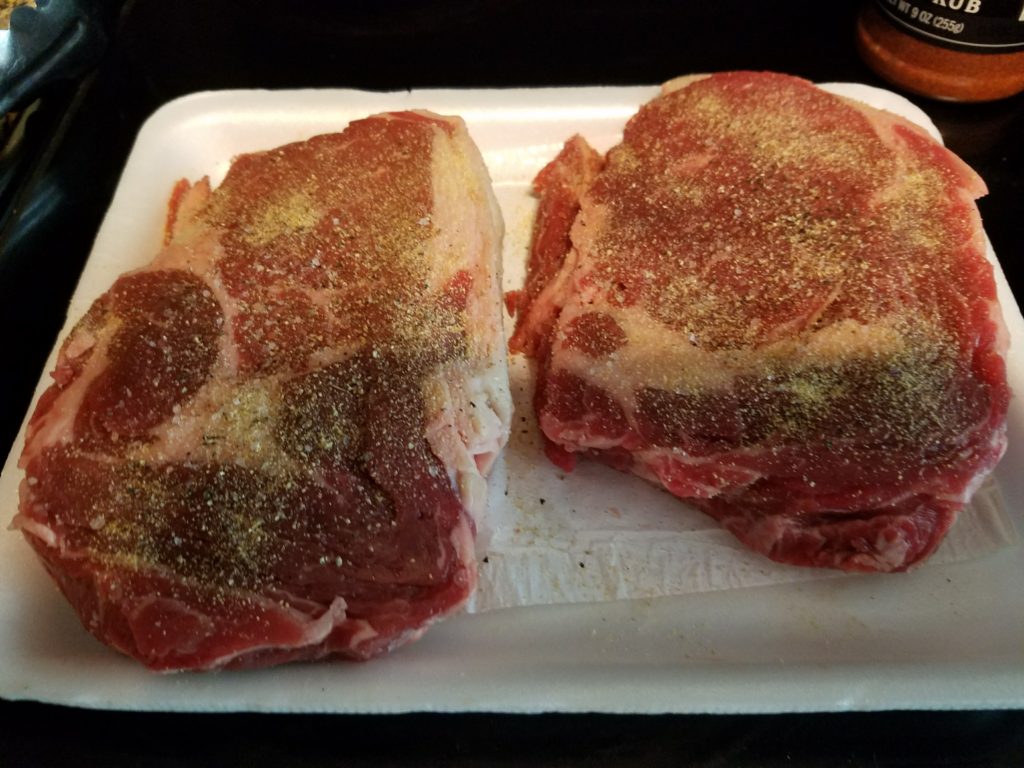 Raw ribeyes seasoned