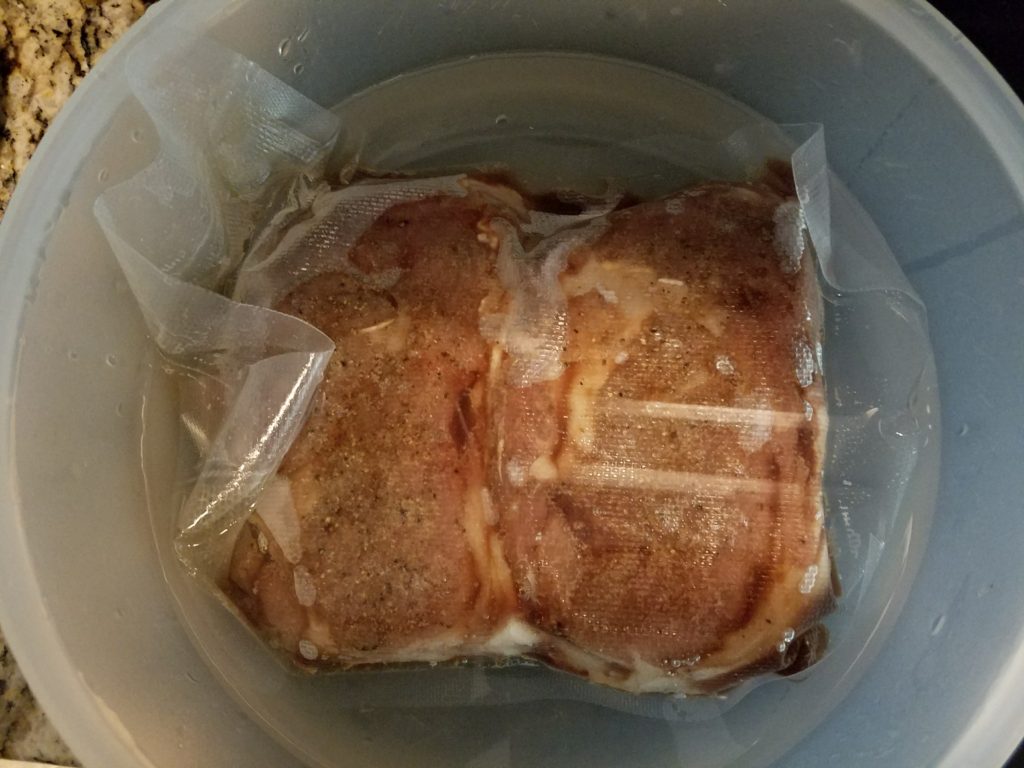 Ribeyes cooling in an ice bath before smoking