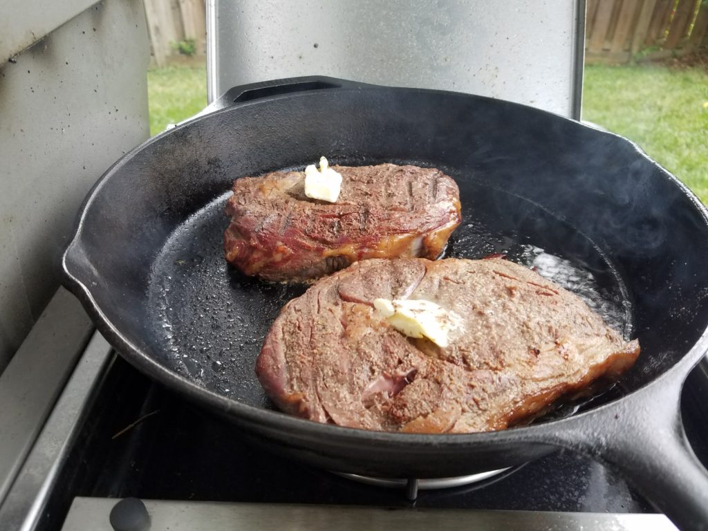 Ribeyes searing in the cast iron pan alternate