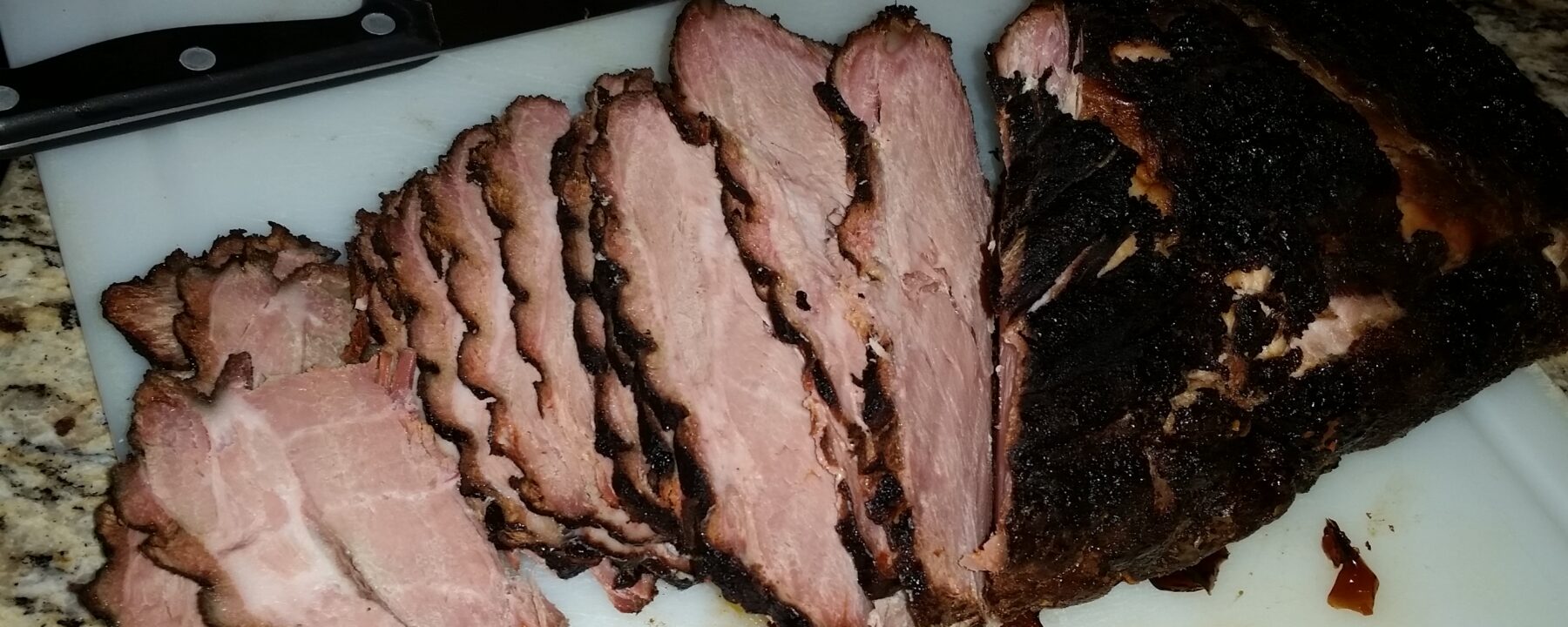 Sliced smoked pork butt on a cutting board