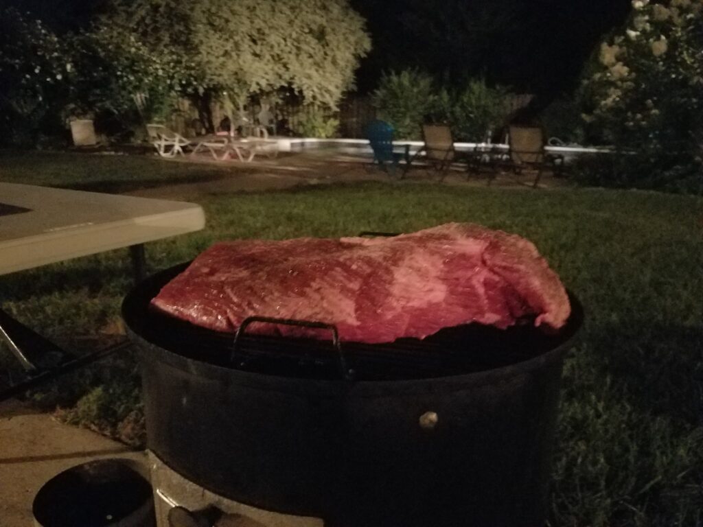 Brisket smoking overnight in the backyard at night