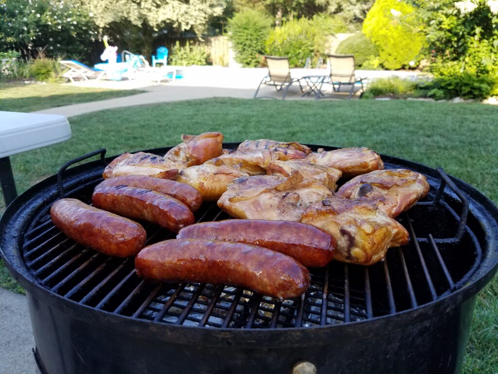 Chicken and sausage further along on the smoker, deep color developing