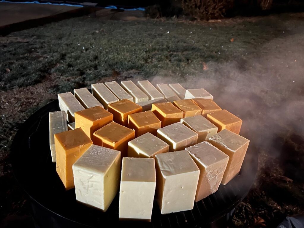 Large batch of white and yellow cheddar arranged on both WSM grates