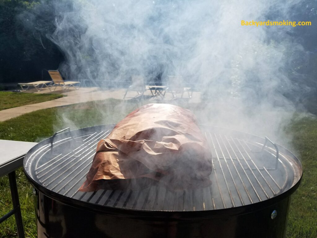 Wrapped brisket smoking on the 22 inch WSM in early morning light